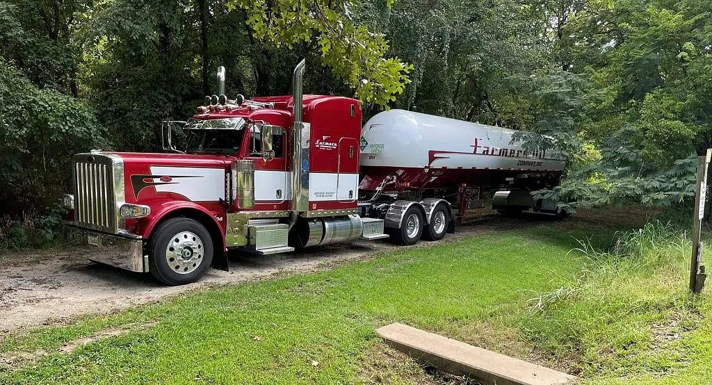 Maroon Farmers Oil Peterbilt and propane transport parked on a grassy roadside