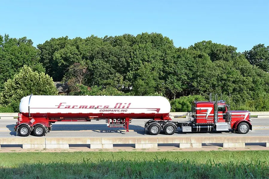 Red Farmers Oil Peterbilt and white propane transport on the highway