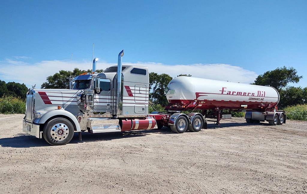 Silver Farmers Oil Peterbilt hauling a white propane transport