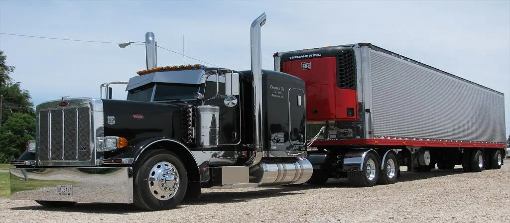 Black Farmers Oil Peterbilt pulling a refrigerated trailer