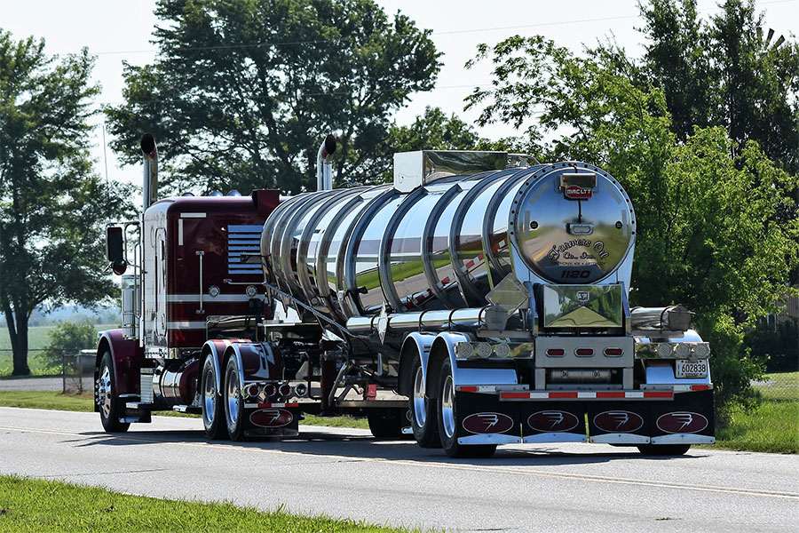 Farmers Oil Peterbilt pulling a polished chrome tanker past green trees
