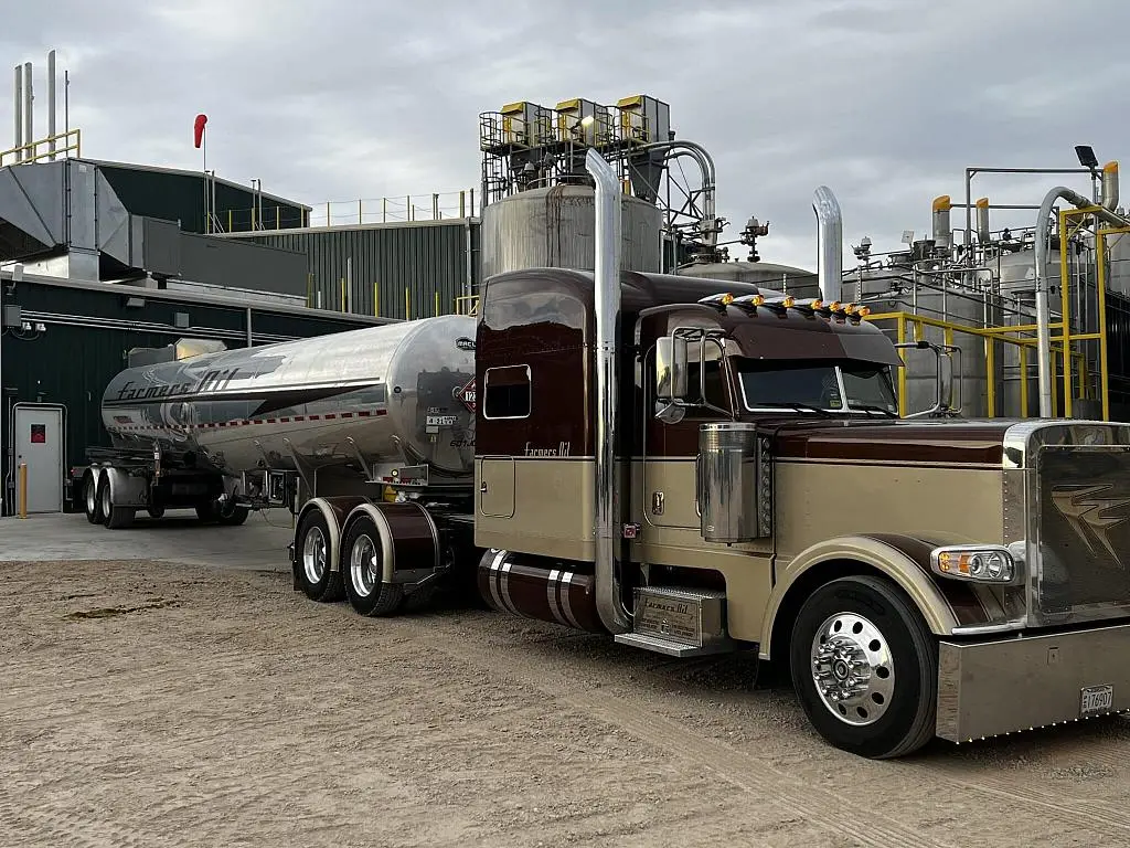 Tan Farmers Oil Peterbilt and tank trailer at a loading terminal