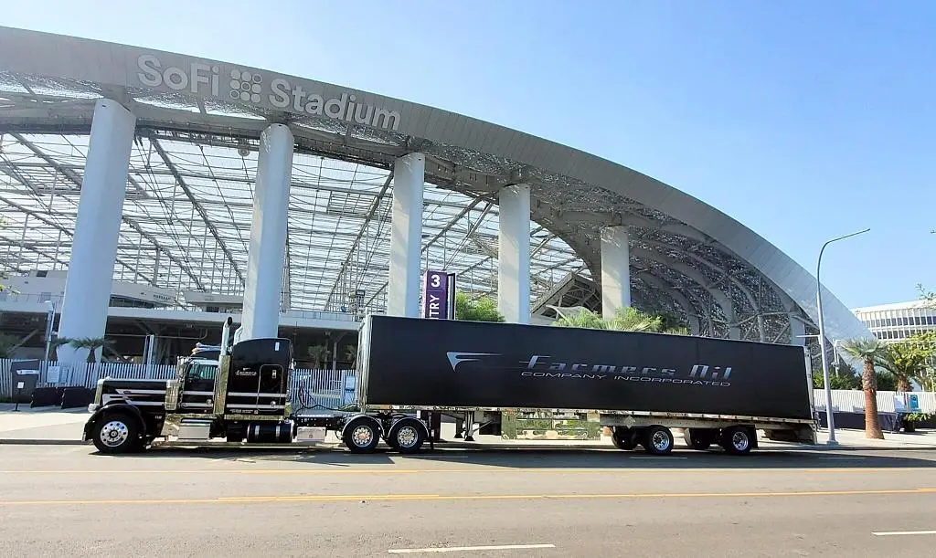 Farmers Oil truck and black van trailer parked outside SoFi Stadium in Los Angeles